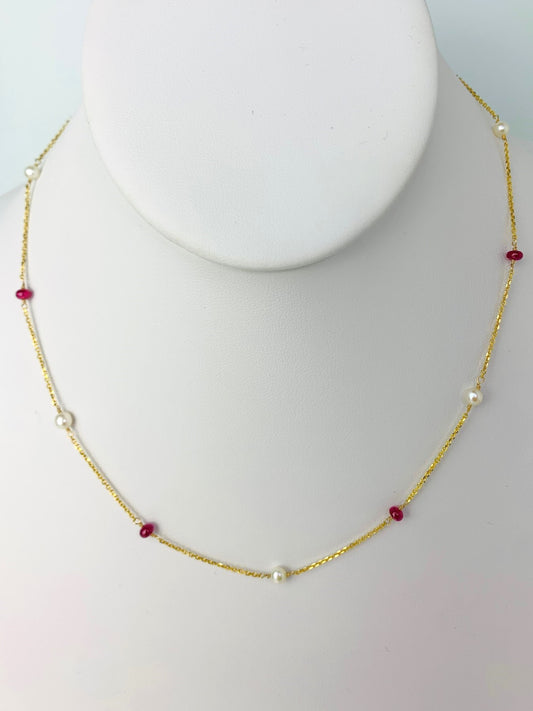 smooth ruby rondelles and white round pearls in stations around a yellow gold chain