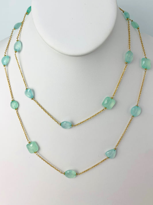 multishape bluish green checkerboard gems wrapped in stations with gold rondelle accents around a 36" long yellow gold chain