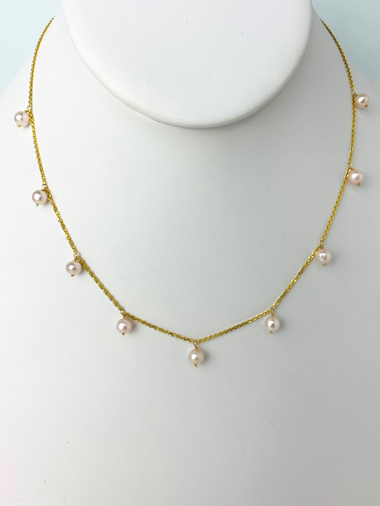 pink freshwater pearls dangling in stations on a yellow gold chain