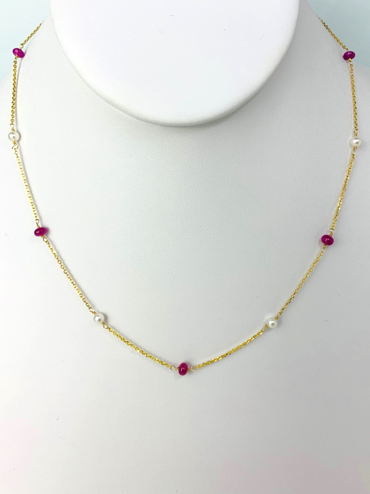 ruby smooth rondelle beads and round white freshwater pearls in stations around a yellow gold chain